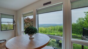 A room with a large window offering a view of greenery and mountains. - Unreal Mountain Views w/ Hot tub Near Charming Jim Thorpe & Blue Mountain Skiing (Jim Thorpe)