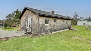A single-story wooden house with a sloped roof, a front porch, and a small front yard. - Day Trip to Acadia: Quiet Coastal Maine Escape (Harrington)