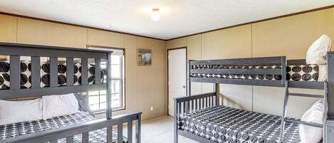 Una habitación con literas, una puerta y una ventana.