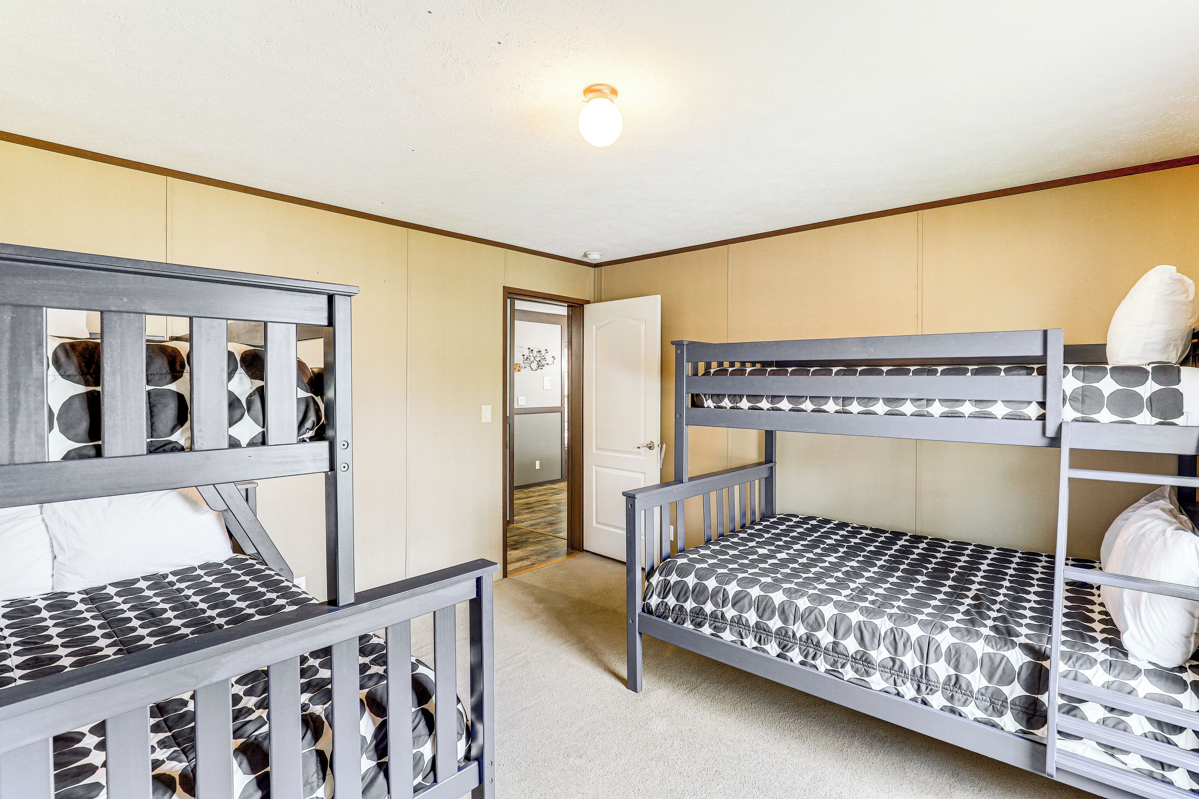 A room with two bunk beds, a door, and a light fixture.