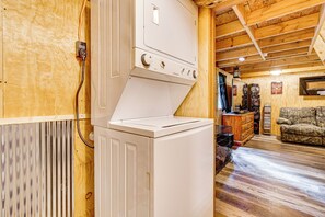 A laundry area with a white washer and dryer, wooden walls, and a rustic interior. - Peaceful Hunting Cabin < 3 Mi to Sam Dale Lake! (Johnsonville)