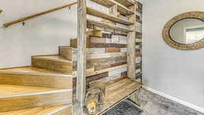 Eine Holztreppe mit rustikalem Design, einschließlich einer Bärenskulptur am Fuß.