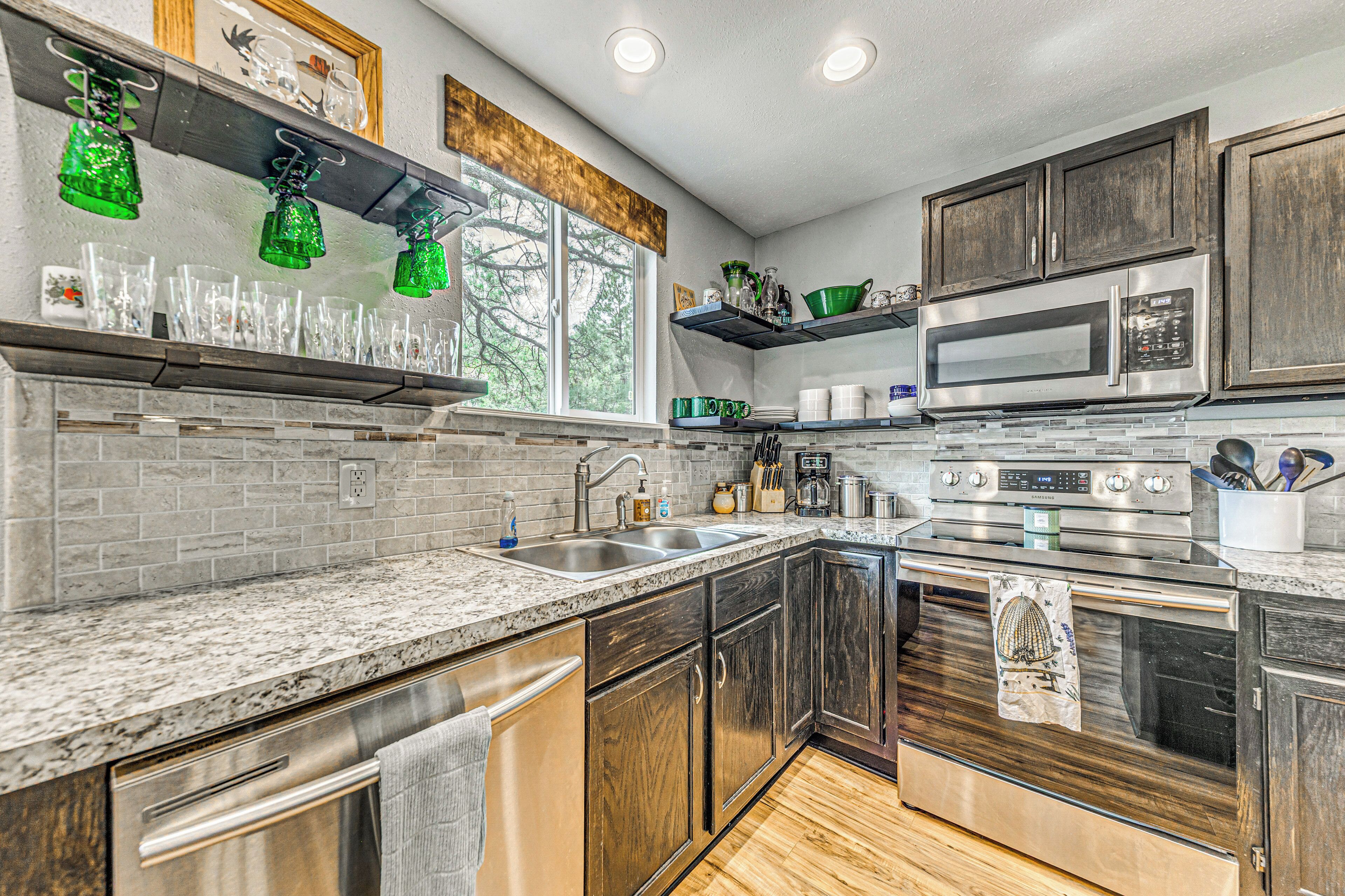 Una cucina moderna con piani di lavoro in granito, elettrodomestici in acciaio inossidabile e mobili in legno.