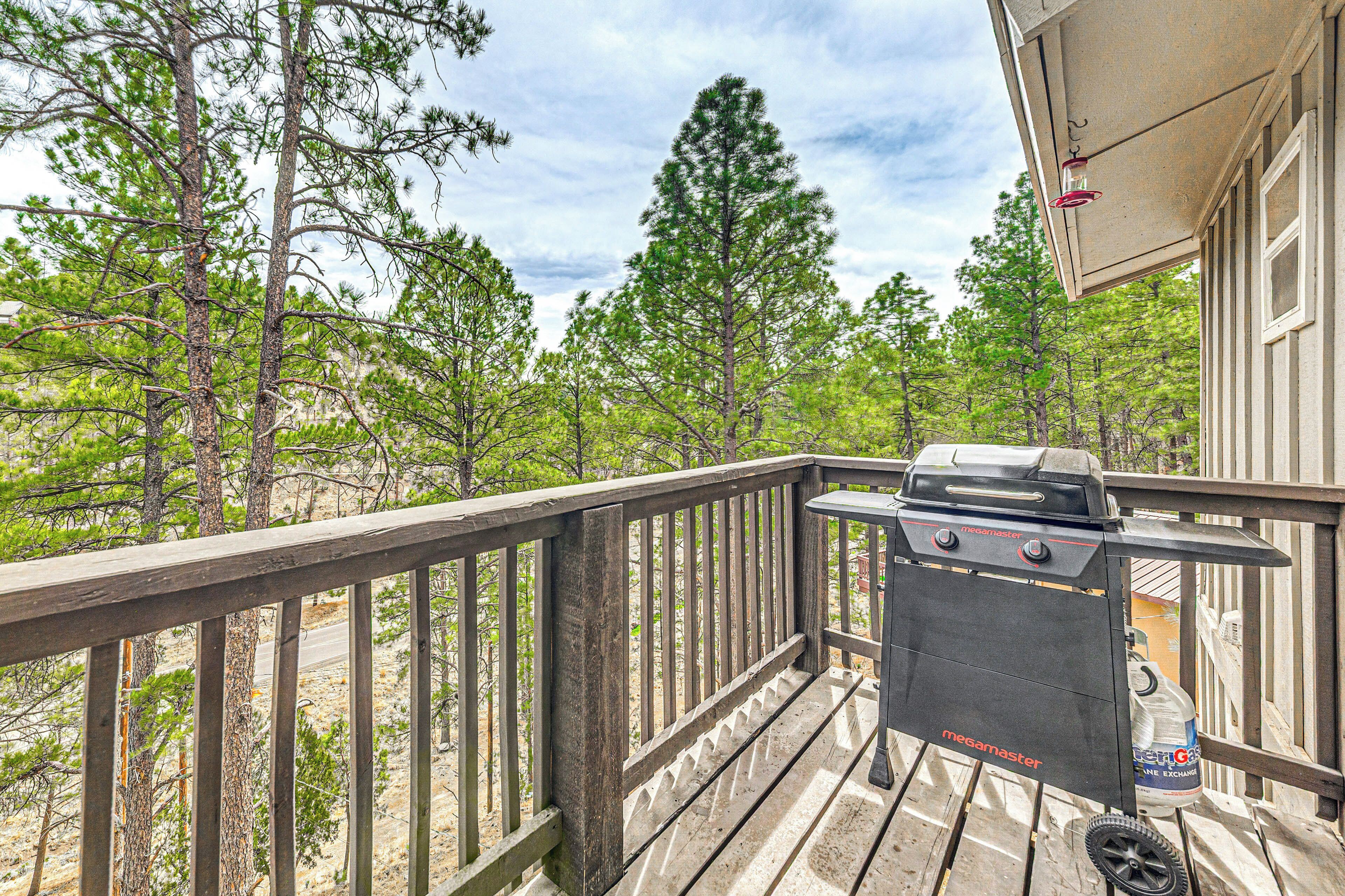 A wooden deck with a Megamaster grill, a water dispenser, and a hanging light fixture.