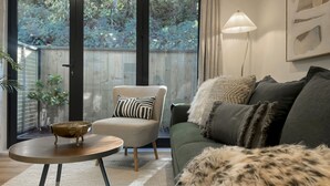 Een moderne woonkamer met een bank, fauteuil en een rond salontafeltje.