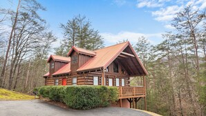 A log cabin with a red roof, a balcony, and a mailbox. - Unforgettable Luxury Mountain Getaway (PIGEON FORGE)