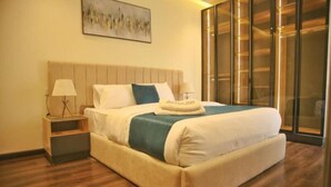A hotel room with a large bed, a nightstand, a lamp, a painting on the wall, and a sliding door closet. - Settle Inn Cairo Festival City Villa (New Cairo)