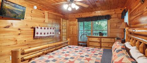 Una habitación de cabaña de madera con cama, una silla, un aparador y una ventana.