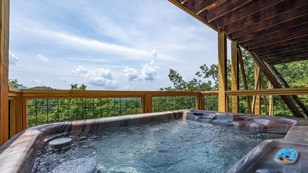 A hot tub with a wooden deck and a view of a forested area. - Peace And Quiet With Incredible Views (PIGEON FORGE)