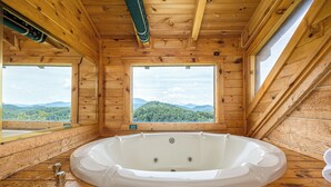 A wooden cabin with a large bathtub and two windows offering mountain views. - Peace And Quiet With Incredible Views (PIGEON FORGE)