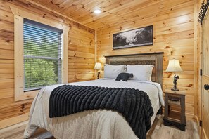 Drift off in your cozy bedroom, wrapped in rustic wood warmth and soft linens, with gentle light filtering through the window to greet your mornings.