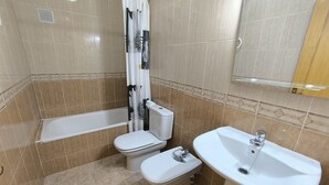 Une salle de bain comprenant des toilettes, un bidet et un lavabo.