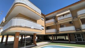 Un immeuble à plusieurs étages doté de balcons, d’une piscine et d’espaces de détente en plein air.
