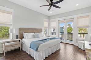Un dormitorio con cama, mesita de noche, lámpara y ventilador de techo.