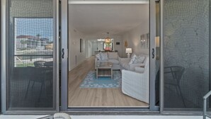 Ein modernes Wohnzimmer mit einer Couch, einem Couchtisch und einem gemusterten Teppich.
