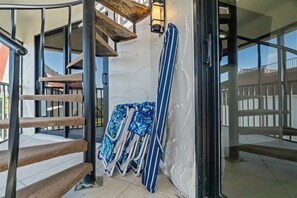 Una escalera de caracol con barandillas de metal y pasamanos de madera, que conduce a un balcón con vistas.