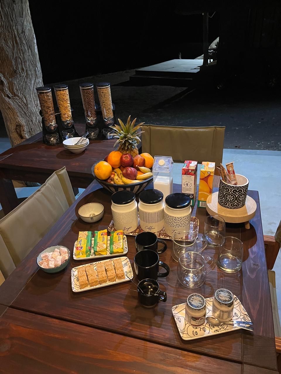 A table set for breakfast with various food items, including fruits, pastries, and beverages.