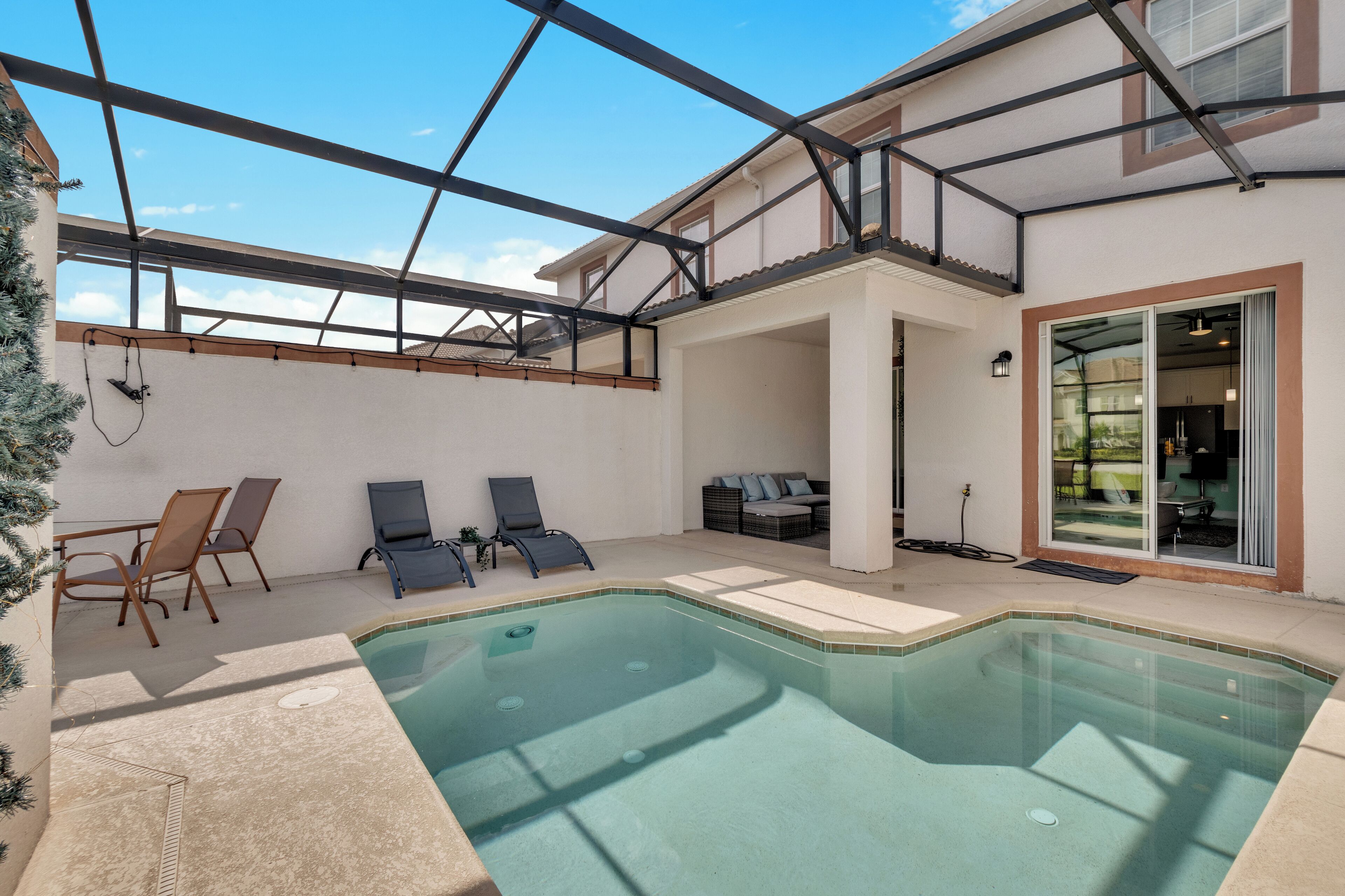 A swimming pool with lounge chairs and a covered patio area.