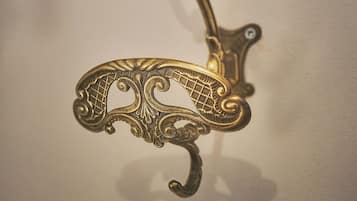 A brass wall hook with an ornate design.