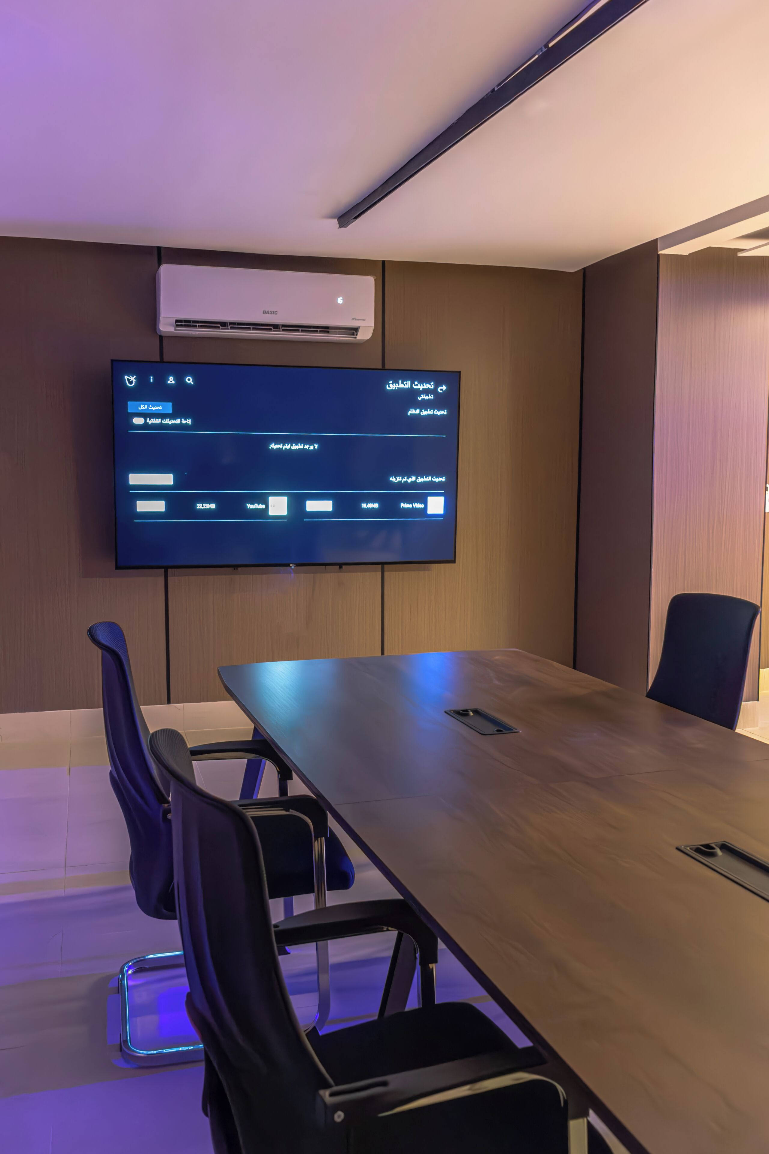 Une salle de conférence équipée d’un grand écran plat fixé au mur, sur lequel est affichée une interface numérique.