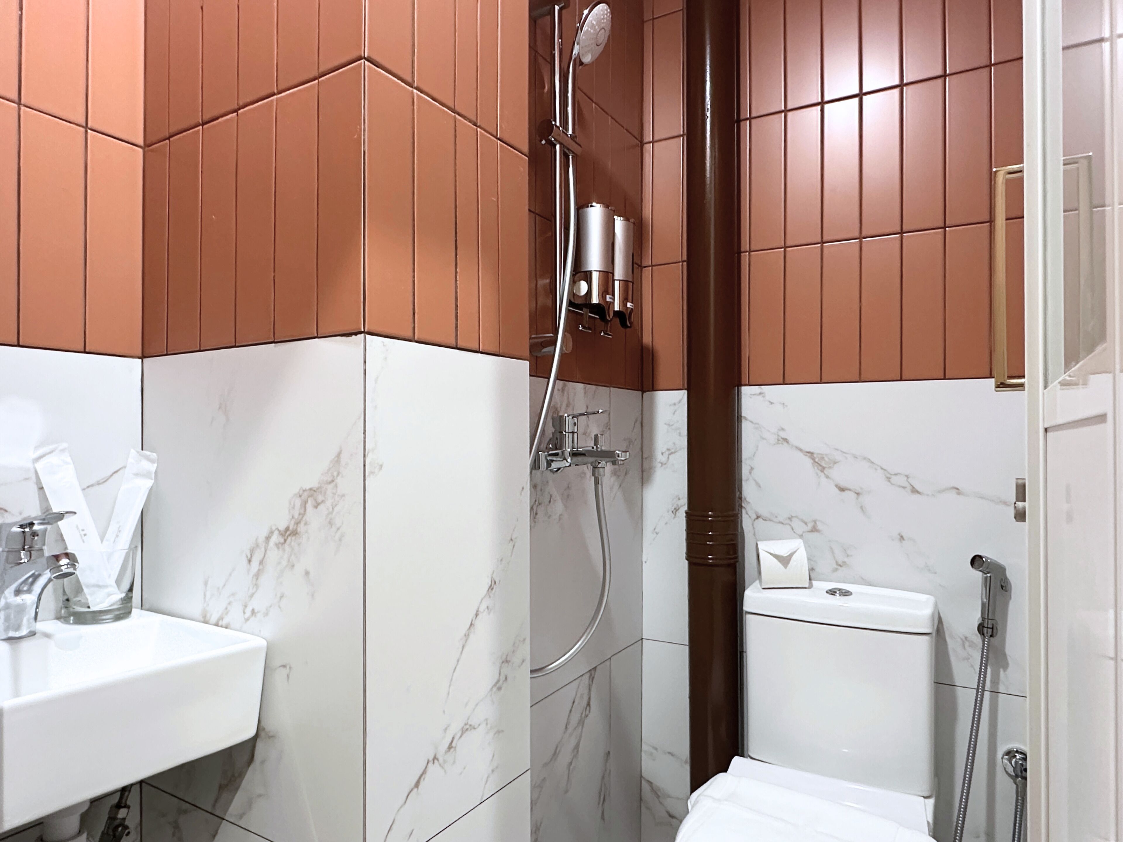 Ein Badezimmer mit weißem Waschbecken, einer Dusche und einer Toilette.