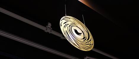 A ceiling with a circular light fixture and exposed ductwork.