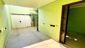 A corridor with a tiled floor, a sliding door, and a gate. - House near Pampulha (Contagem)