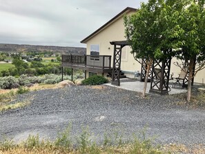 Enjoy a balcony with stairs, surrounded by lush vegetation and a distant view of hills.