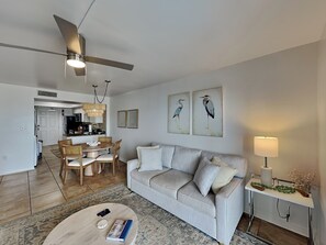 Un salon comprenant un canapé, une table basse et un coin repas avec des chaises et une table.