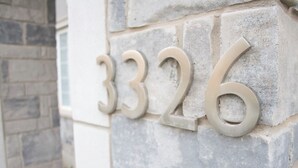 A stone wall with house numbers 3326.