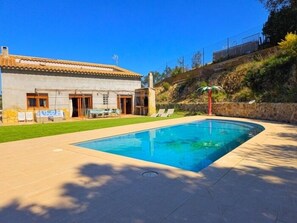 A swimming pool with a house in the background.