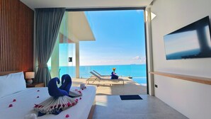 A hotel room with a bed, a TV, a view of the sea, and a balcony with a chair and a vase of flowers. - Santi Pura Villas (Koh Samui)