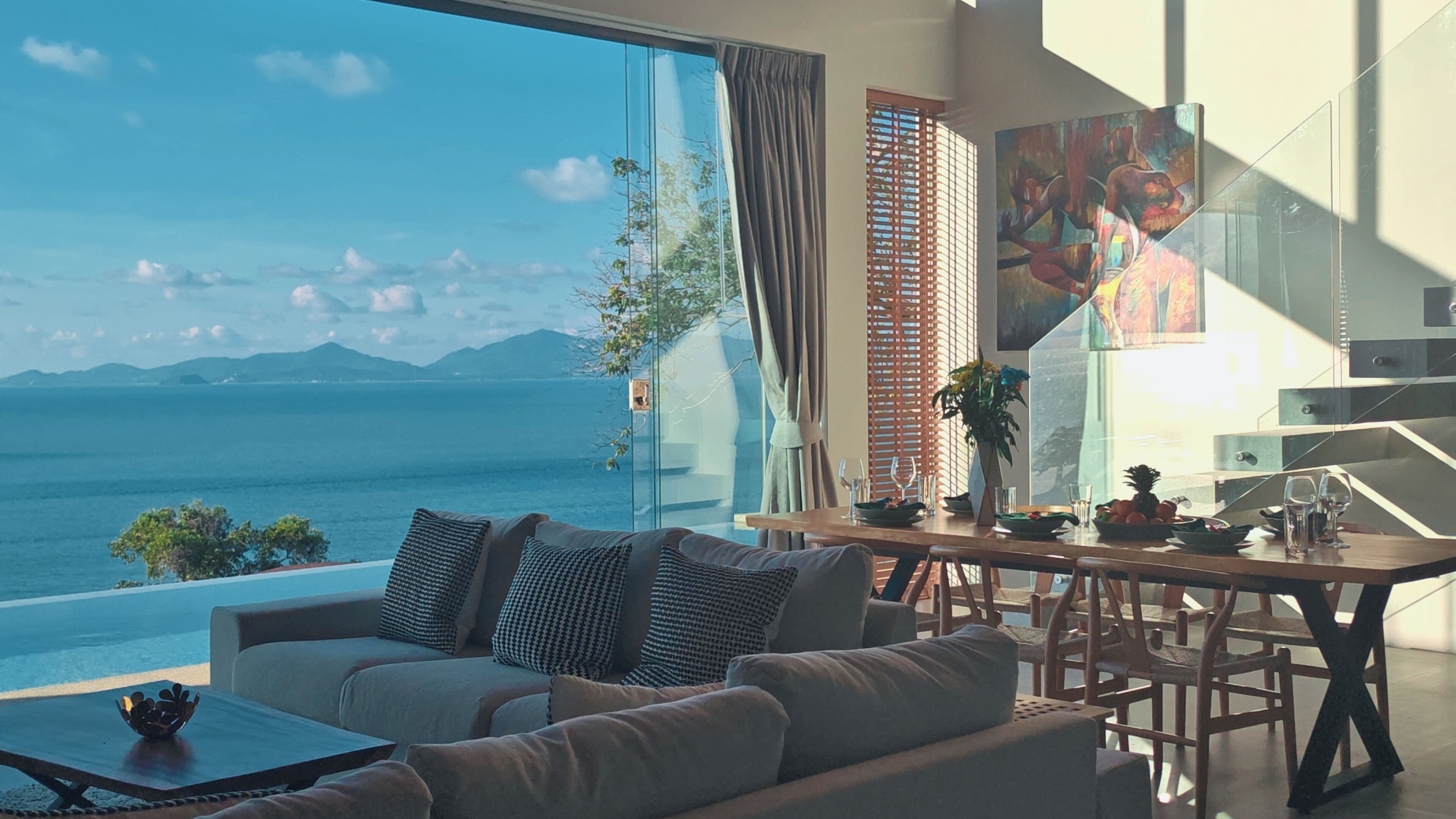 A modern living room with a large window overlooking a scenic ocean view.