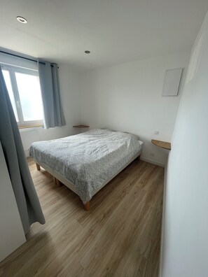 Simple, functional bedroom with a single bed and two nightstands.