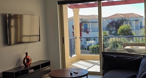A modern living room with a flat-screen TV, a small table, and a sofa. - Cassiopeia 3-Bedroom House on beach with pool (Chania)