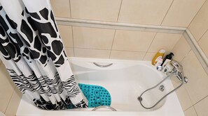 A bathroom with a bathtub, a shower, and a toilet. There are toiletries on the side of the tub. - Cassiopeia 3-Bedroom House on beach with pool (Chania)