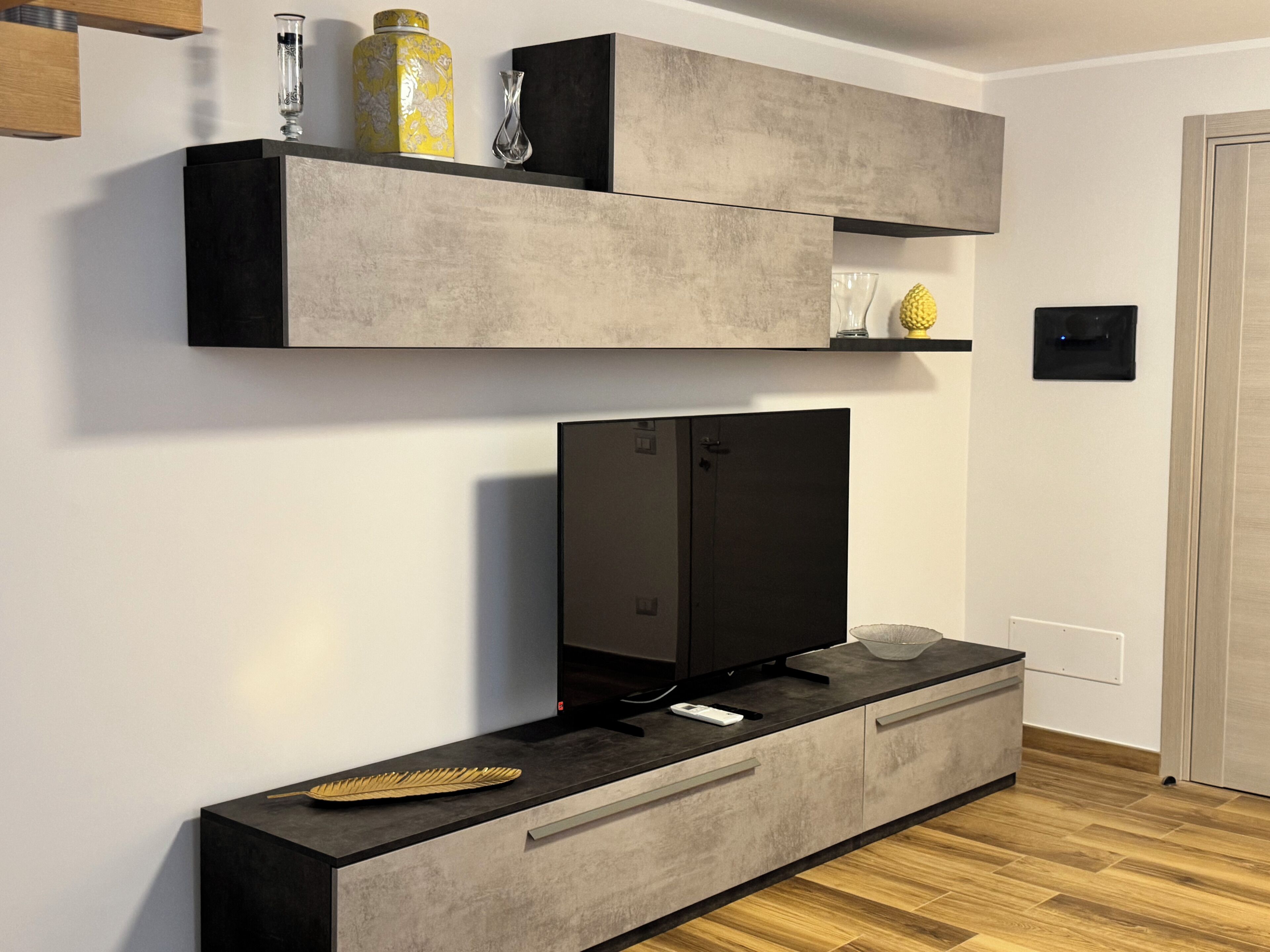 Een moderne woonkamer met een flatscreen televisie, inbouwkasten en een console tafel.