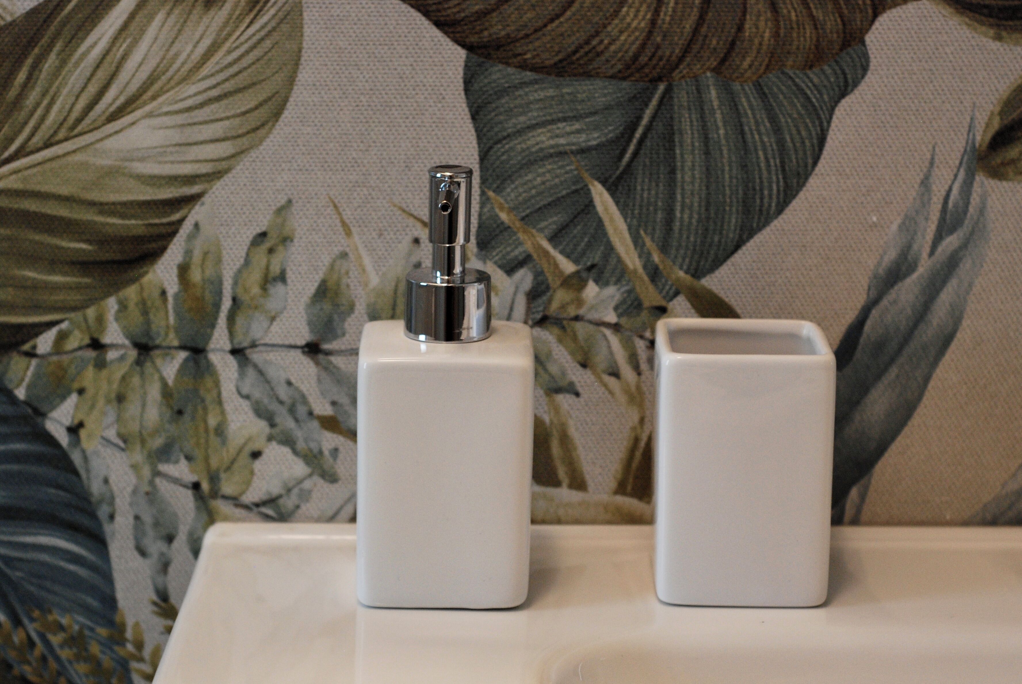 Deux objets rectangulaires blancs sont posés sur une surface dont le fond est orné d’un motif floral.
