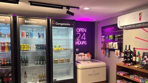 Una tienda de conveniencia abierta las 24 horas, con estantes llenos de aperitivos, bebidas y salsas.
