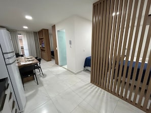 A compact living space with a dining area, a kitchenette, and a bedroom. - Bela Hospedagem - 105 Compact Tambau (João Pessoa)
