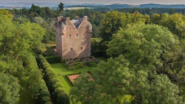A castle surrounded by lush greenery, with a well-maintained lawn and a small pond. - Spedlins Castle – A Magical Escape in the Scottish Countryside (Templand)