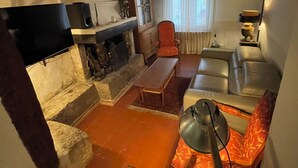 En hyggelig stue med pejs, sofa, sofabord og fjernsyn.