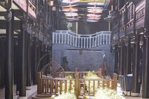 A courtyard with a central seating area, surrounded by columns and a patterned wall. - DuoFu Resort (Lijiang Ancient City South Gate) (Lijiang)