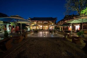 A traditional building with a courtyard, outdoor seating, and umbrellas. - DuoFu Resort (Lijiang Ancient City South Gate) (Lijiang)