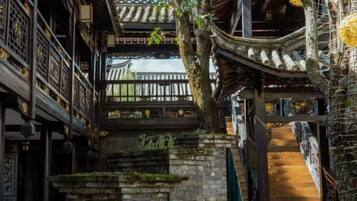 A traditional multi-story building with wooden balconies and a staircase.