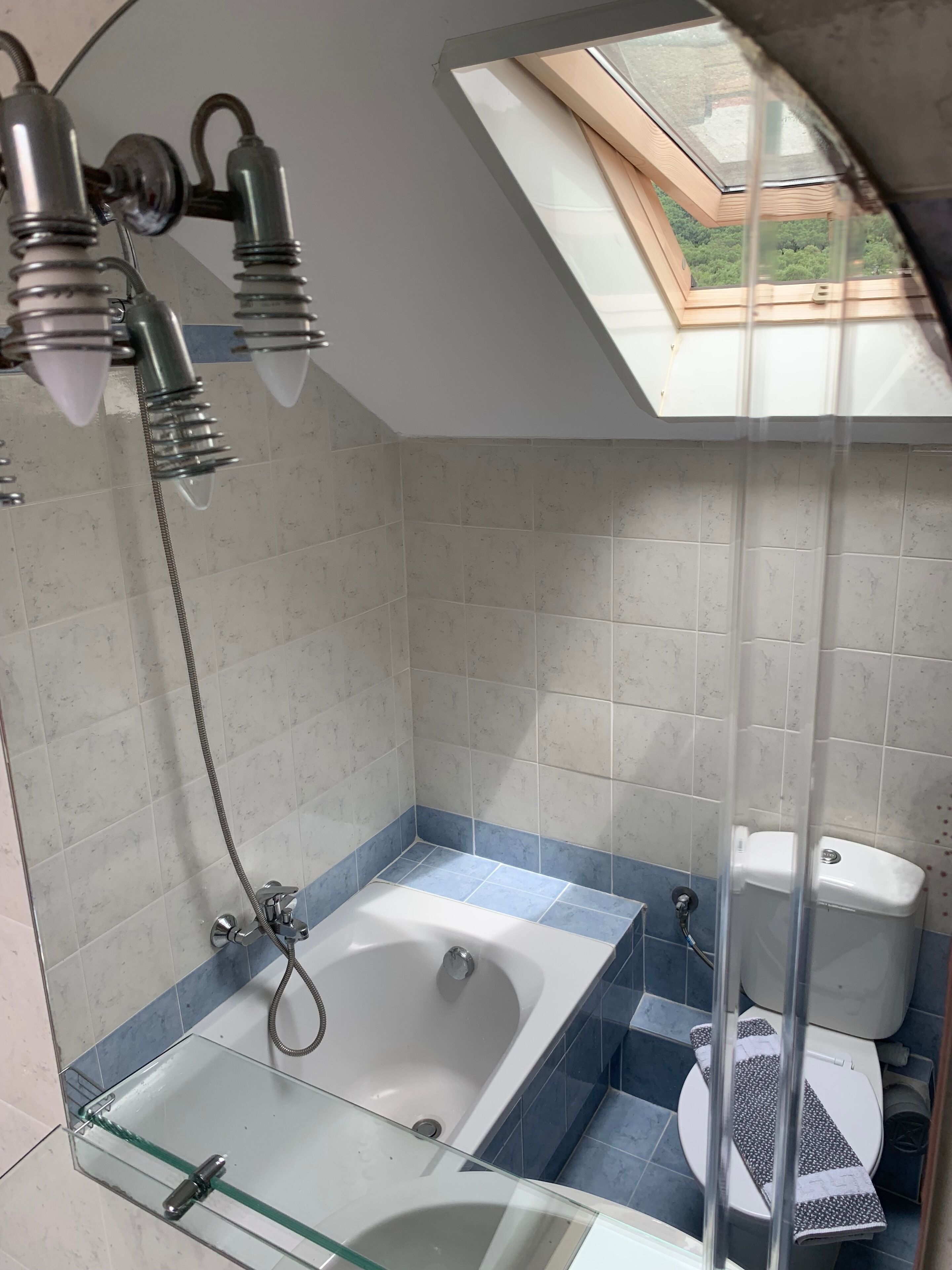 A bathroom with a glass-enclosed shower, a bathtub, and a toilet.