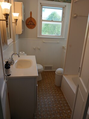 Un baño con lavamanos, inodoro y ventana.