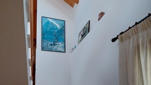 A staircase with wooden steps and a wooden handrail, leading to a room with a skylight and two framed pictures on the wall. - Rural House with authentic apartments 1.340m, with garden, bbq and terrace (Senet)