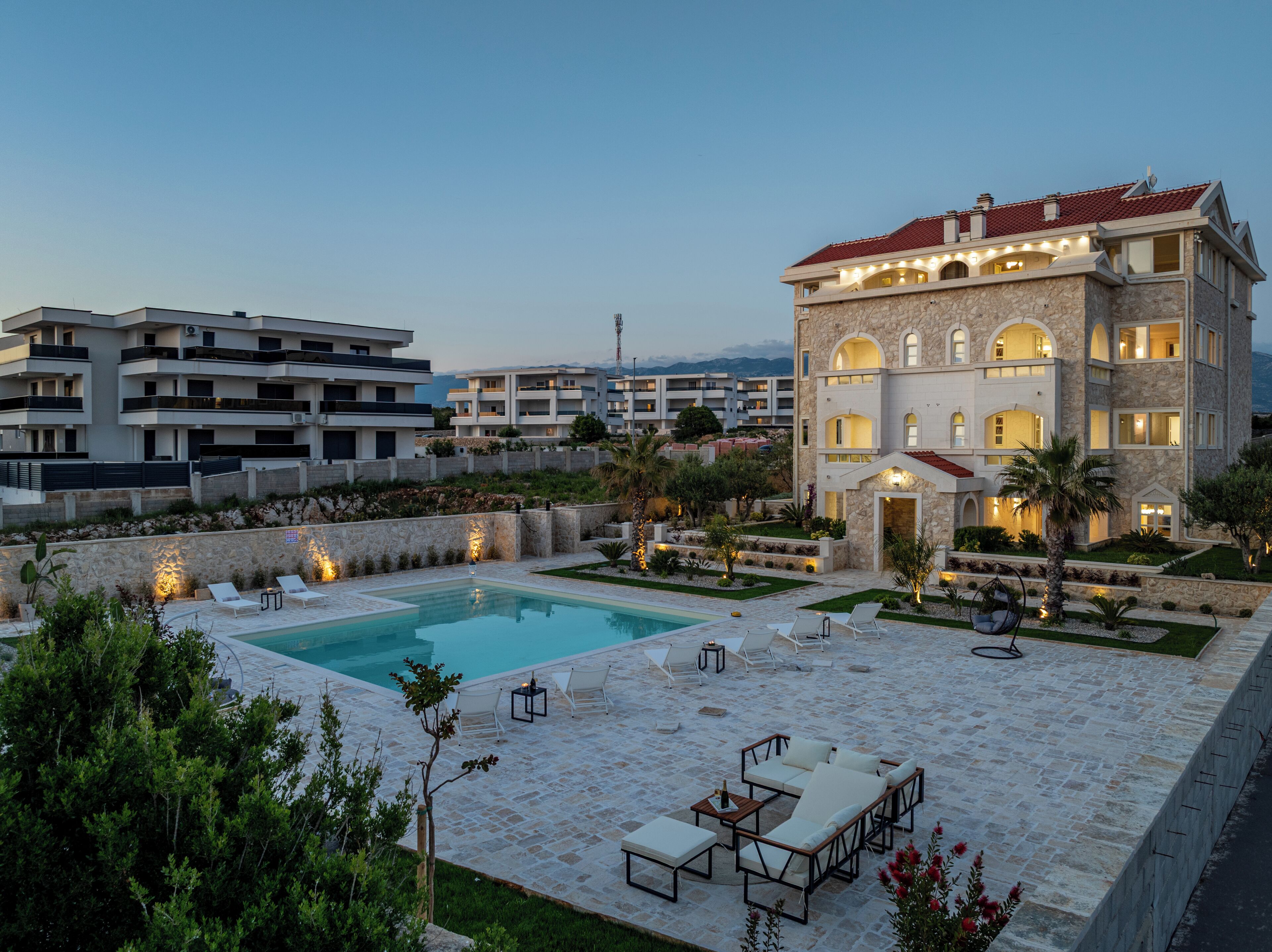 A pool area with lounge chairs and a stone patio.
