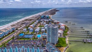 A coastal resort with beachfront properties, a marina, and a large hotel building.